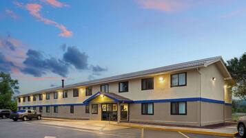 A two-story motel with a flat roof and a blue trim line.