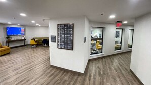 A modern office space with a reception area, a large flat-screen TV, and a wall-mounted menu board.
