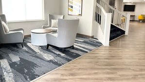 A modern living room with a sofa set, a coffee table, and a patterned rug.