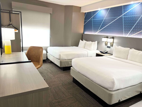 A hotel room with two beds, a desk, a chair, and a large wall with a geometric pattern. - Comfort Inn Marietta-Atlanta near Ballpark/Galleria (Marietta)