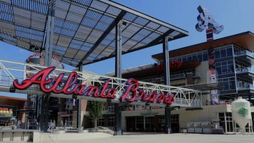 El estadio de los Atlanta Braves con un gran letrero que dice 'Atlanta Braves' y una estatua de mascota.