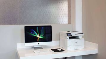 A modern office desk with an Apple iMac, HP printer, keyboard, and mouse.