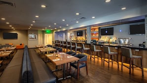 Un restaurante con cabinas, mesas y una zona de bar.