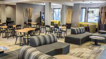 Un espace de détente moderne, aménagé avec des sièges, des tables et une machine à café.