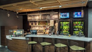 Eine moderne Bar mit einer gebogenen Theke, Barhocker und mehreren Fernsehern, die Nachrichtensender zeigen.