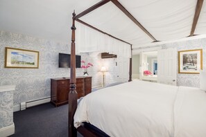 A bedroom with a four-poster bed, a dresser, a TV, and a mirror. - Simsbury 1820 House (Simsbury)