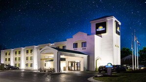 A Days Inn hotel with a central entrance, multiple windows, and a flagpole with flags. - Days Inn by Wyndham Blue Springs (Blue Springs)