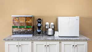 A kitchen counter with a coffee machine, a refrigerator, and a snack dispenser. - Econo Lodge Belton - Kansas City South (Belton)