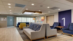 A modern waiting area with a sofa, armchairs, and a small table.