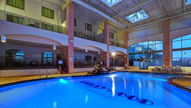 A large indoor swimming pool with a view of the city skyline through large windows. - Hollywood Casino Tunica (Robinsonville)