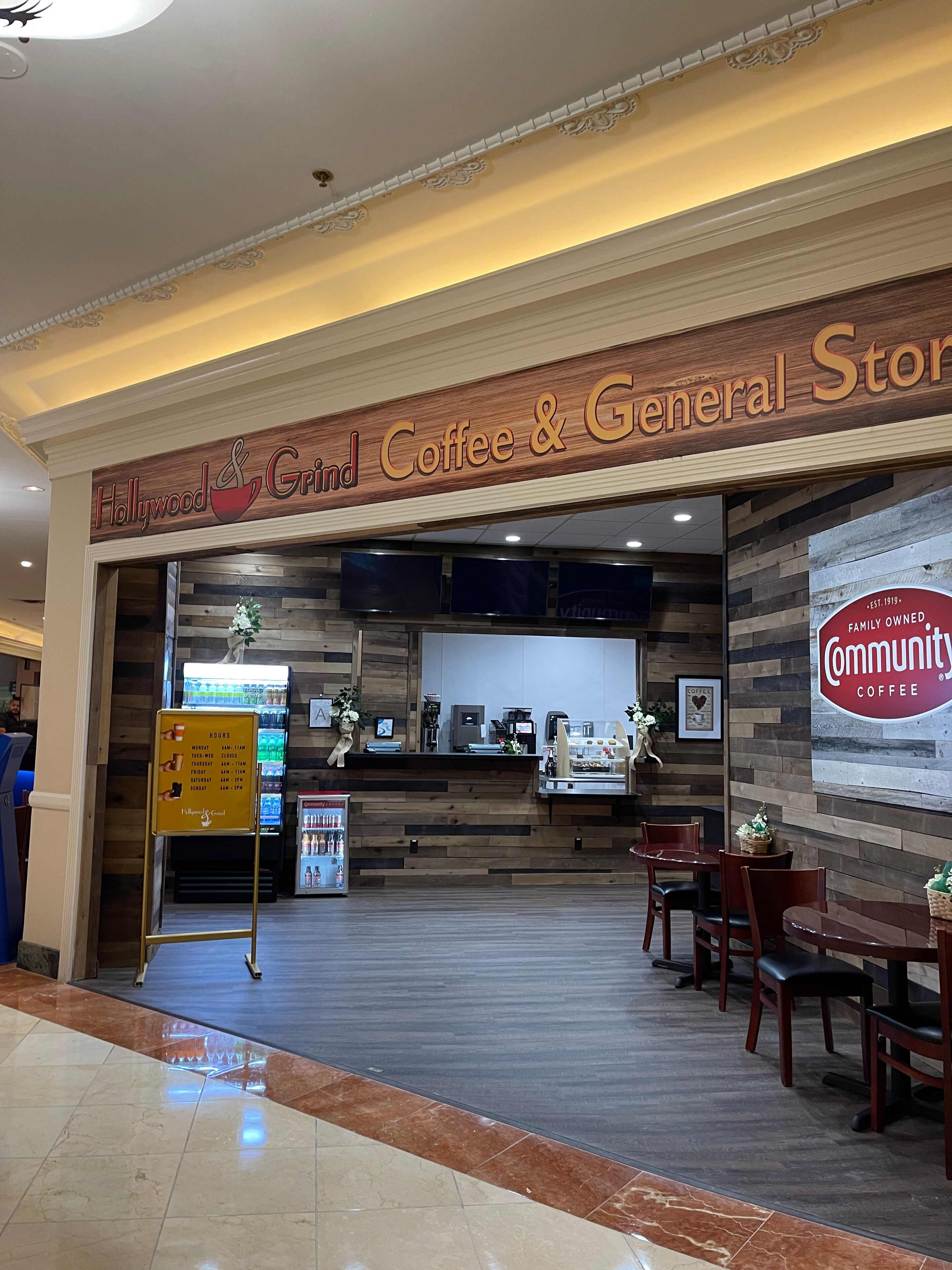 Ett kafé med en träskylt där det står: ”Hollywood Grind Coffee & General Store”.