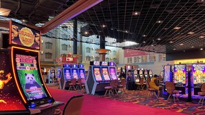 A casino with multiple slot machines, a red carpet, and a high ceiling with metal beams. - Hollywood Casino Tunica (Robinsonville)