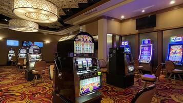 A casino area with slot machines, a large chandelier, and a carpeted floor.