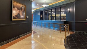 A hotel lobby with a bar area, a large framed artwork on the wall, and a pool visible through the windows. - Hollywood Casino Tunica (Robinsonville)