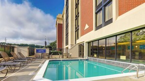A swimming pool with lounge chairs and a sign warning of drowning risk. - Drury Inn & Suites Atlanta Marietta (Marietta)