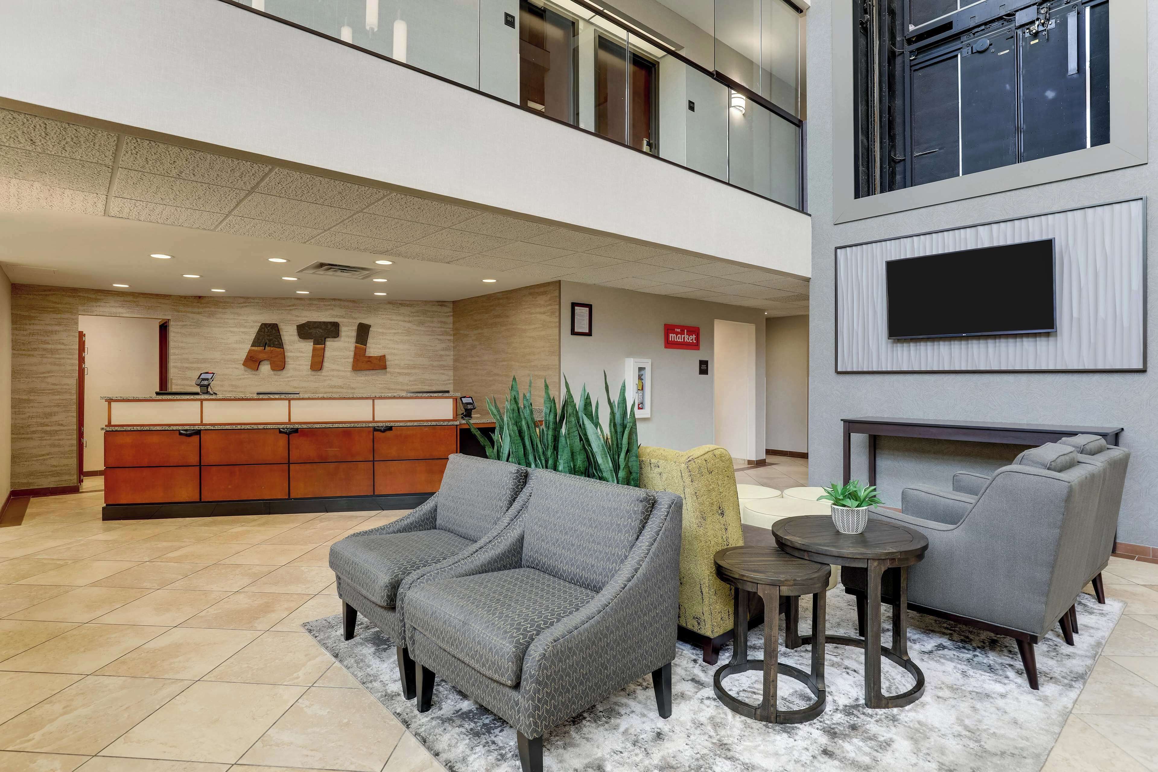 Een lobby met een receptiebalie, een zithoek en een wandgemonteerde flatscreen televisie.