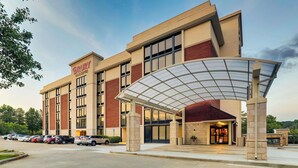 A modern hotel with a covered entrance, multiple parking spaces, and a brick facade. - Drury Inn & Suites Atlanta Marietta (Marietta)