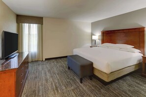 A hotel room with a bed, a TV, a desk, and a lamp. - Drury Inn & Suites Atlanta Marietta (Marietta)