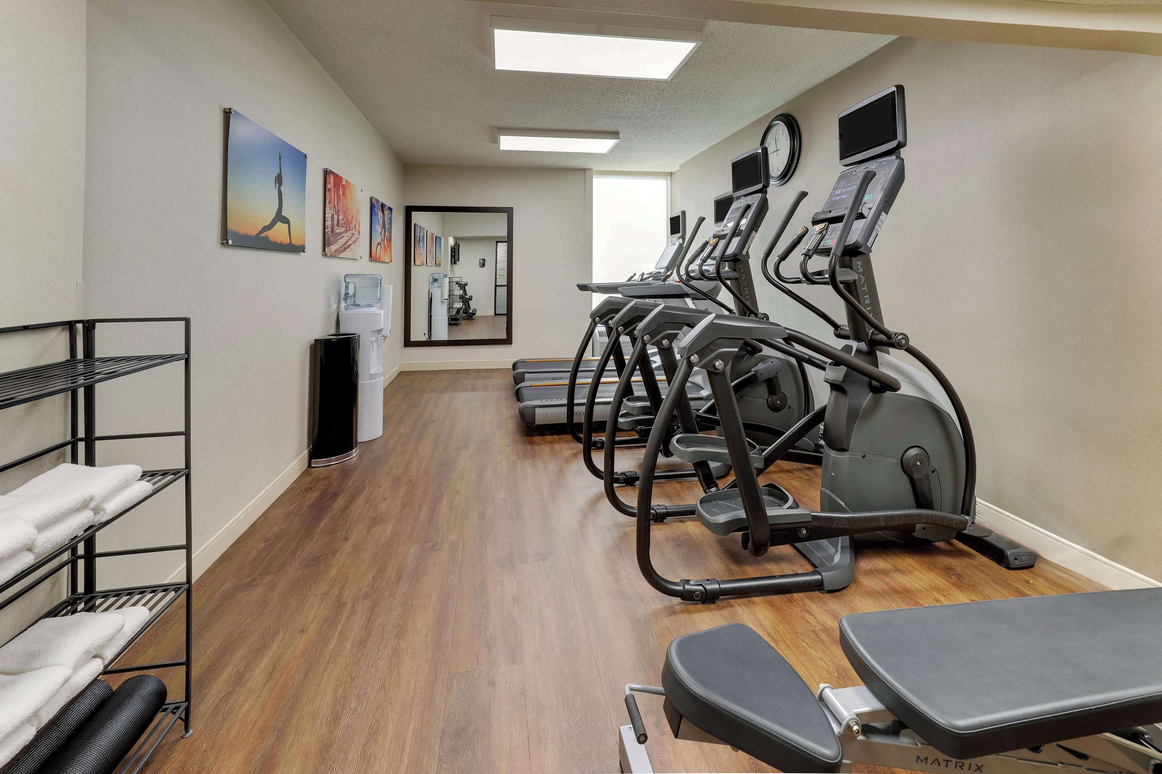 A fitness room with treadmills, a mirror, and exercise equipment.