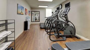 A fitness room with treadmills, a mirror, and exercise equipment.