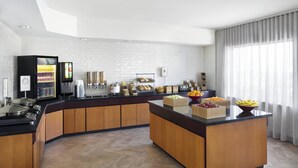 A modern kitchen with a central island, built-in appliances, and a variety of food items displayed. - Fairfield Inn & Suites by Marriott Denver Airport (Denver)