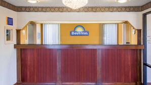 Een receptiebalie bij een Days Inn, met een kroonluchter erboven en een patroon op de muur.