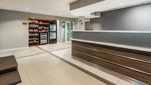 A reception area with a counter, a snack bar, and a refrigerator.