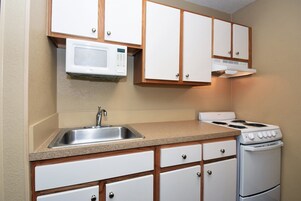 Full-size fridge, microwave, stovetop, cookware/dishes/utensils