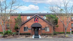 A brick building with a sign indicating '6 suites' and a 'Lobby' sign above the entrance. - Studio 6 Suites Jackson Ridgeland MS (Ridgeland)