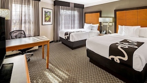 A hotel room with two beds, a desk, a chair, and a TV. - La Quinta Inn & Suites by Wyndham Macon (Macon)