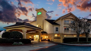 A hotel with a prominent entrance, a covered area, and a landscaped garden. - La Quinta Inn & Suites by Wyndham Macon (Macon)