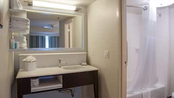 A bathroom with a sink, mirror, towel rack, and shower curtain.