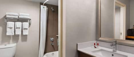 A modern bathroom with a toilet, bathtub, and sink.
