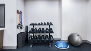 A gym with dumbbells, a blue exercise ball, and a wall-mounted rack. - Holiday Inn Express Atlanta West - Theme Park Area by IHG (Lithia Springs)