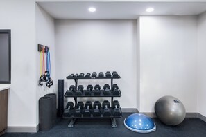 A gym with dumbbells, a blue exercise ball, and a wall-mounted rack. - Holiday Inn Express Atlanta West - Theme Park Area by IHG (Lithia Springs)