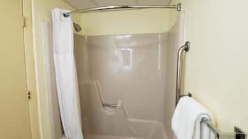 A bathroom with a shower, a towel rack, and a door.