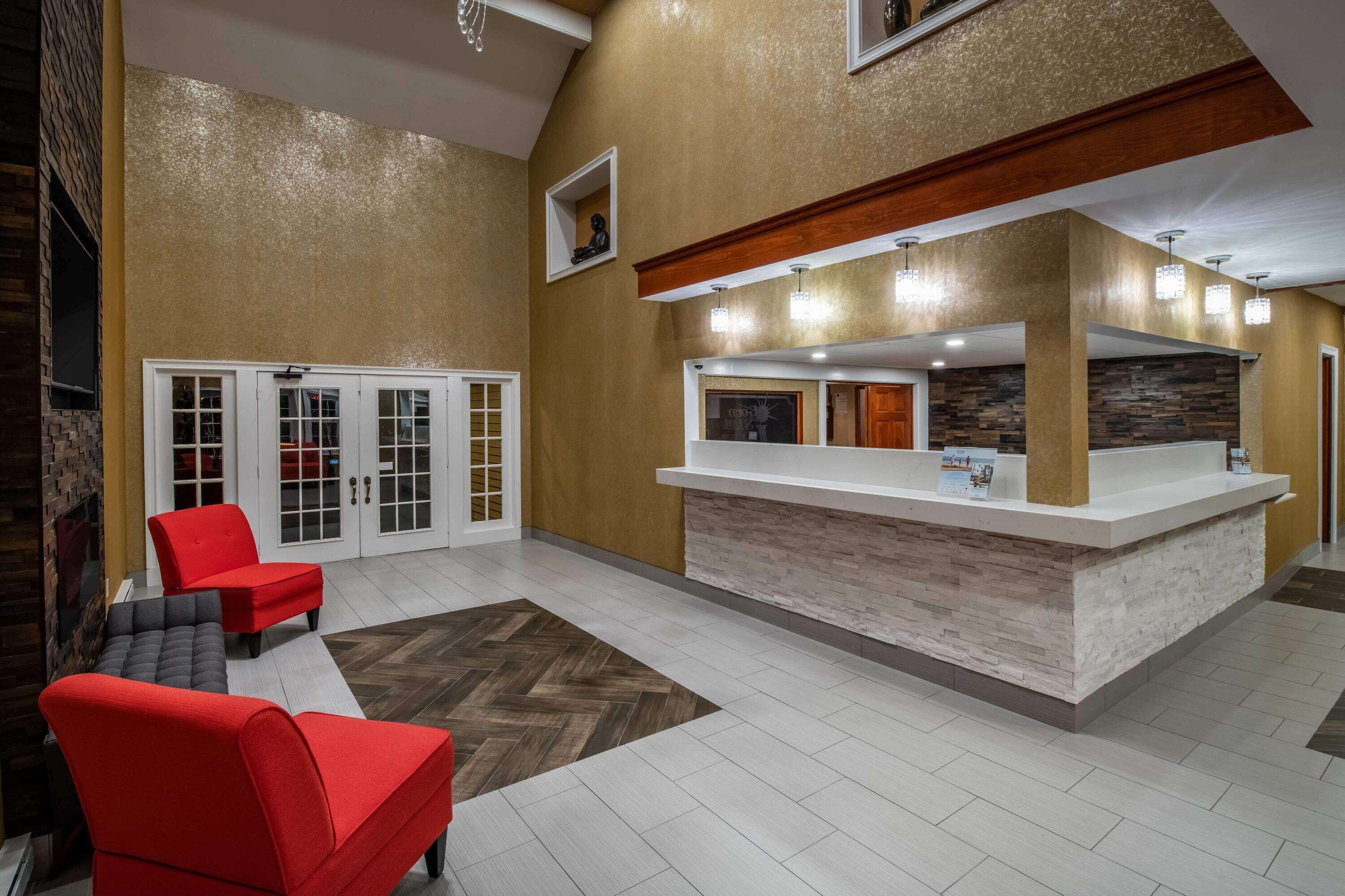 A reception area with a counter, seating, and a herringbone-patterned floor.