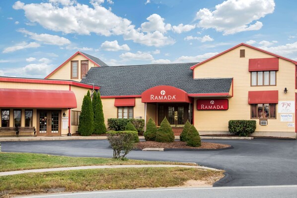 A two-story building with a red awning and a sign that reads "RAMADA."