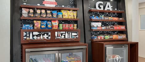 A snack display with various chips and a refrigerated section with drinks.