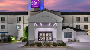 Un hôtel Sleep Inn avec une enseigne bien visible, une entrée abritée et une façade bien entretenue.