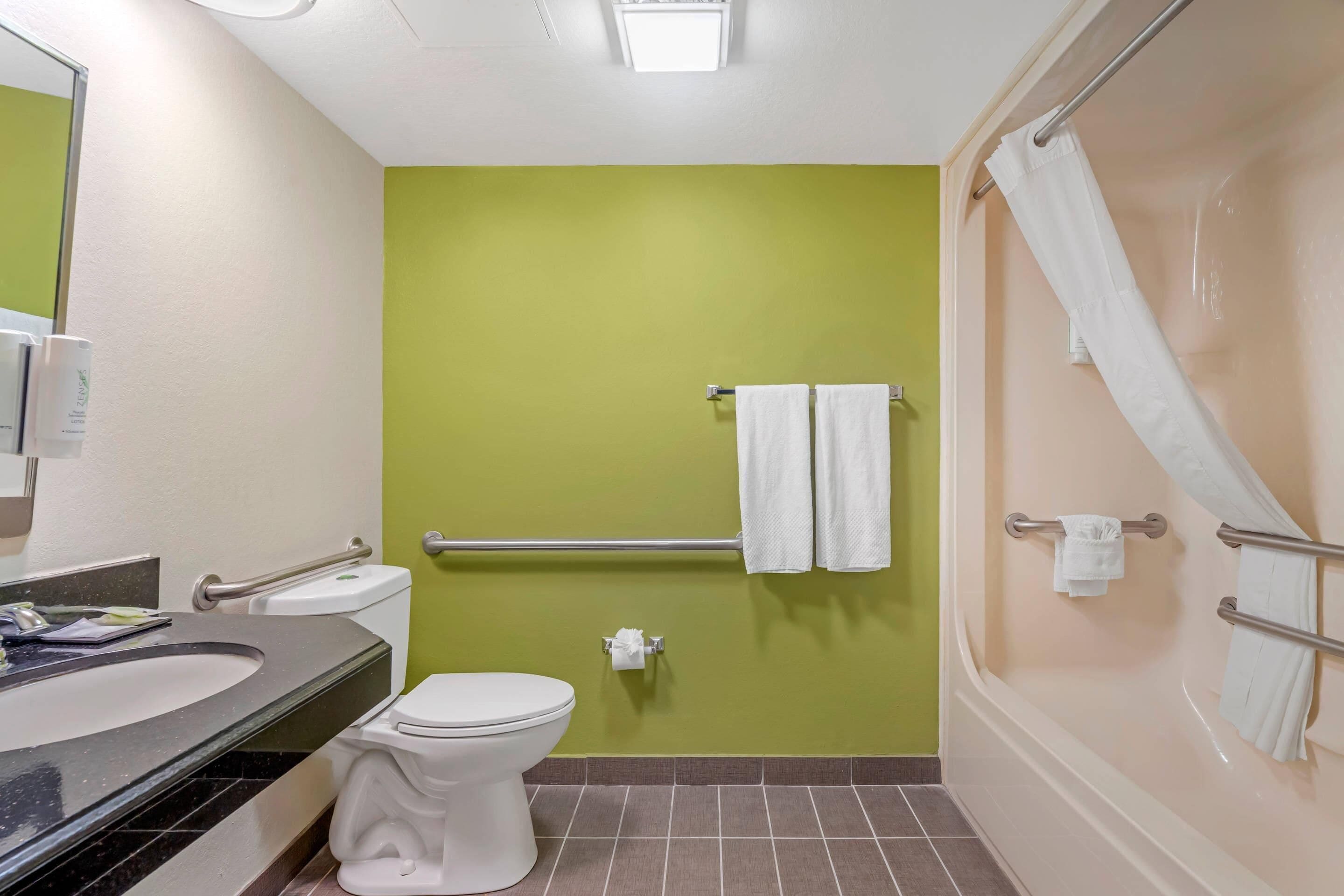 Un baño con inodoro, lavamanos y zona de ducha.
