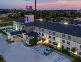 Un hotel con piscina, aparcamiento con plazas para discapacitados y un cartel de Sleep Inn.