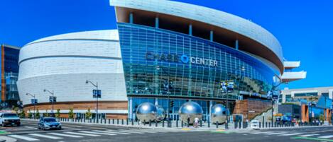A modern building with a curved facade and large glass windows, labeled "CHASE CENTER".