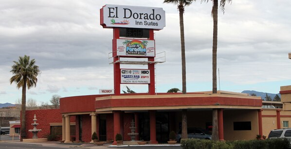 A hotel named El Dorado Inn Suites with a signboard advertising a Taste of Faroe Grill, Wi-Fi, pool & spa, sports bar, and truck-bus parking.