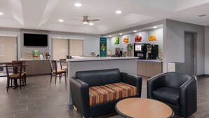 A modern kitchen with a central island, a dining area with chairs, and a seating area with a sofa and a table. - Quality Inn near Casinos and Convention Center (Bossier City)
