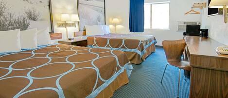 A hotel room with two beds, a desk, a chair, a TV, and a window with a blue curtain.