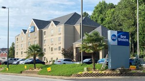 A Best Western hotel with a beige facade, multiple windows, and a parking lot with several cars. - Best Western Kennesaw (Kennesaw)