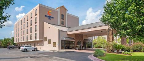 Un hotel Comfort Inn con fachada moderna, un acceso cubierto y un estacionamiento.