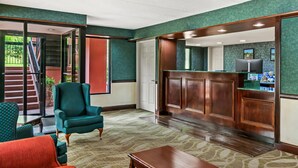 A lobby with a reception desk, a staircase, and a teal armchair. - Econo Lodge Helen (Helen)