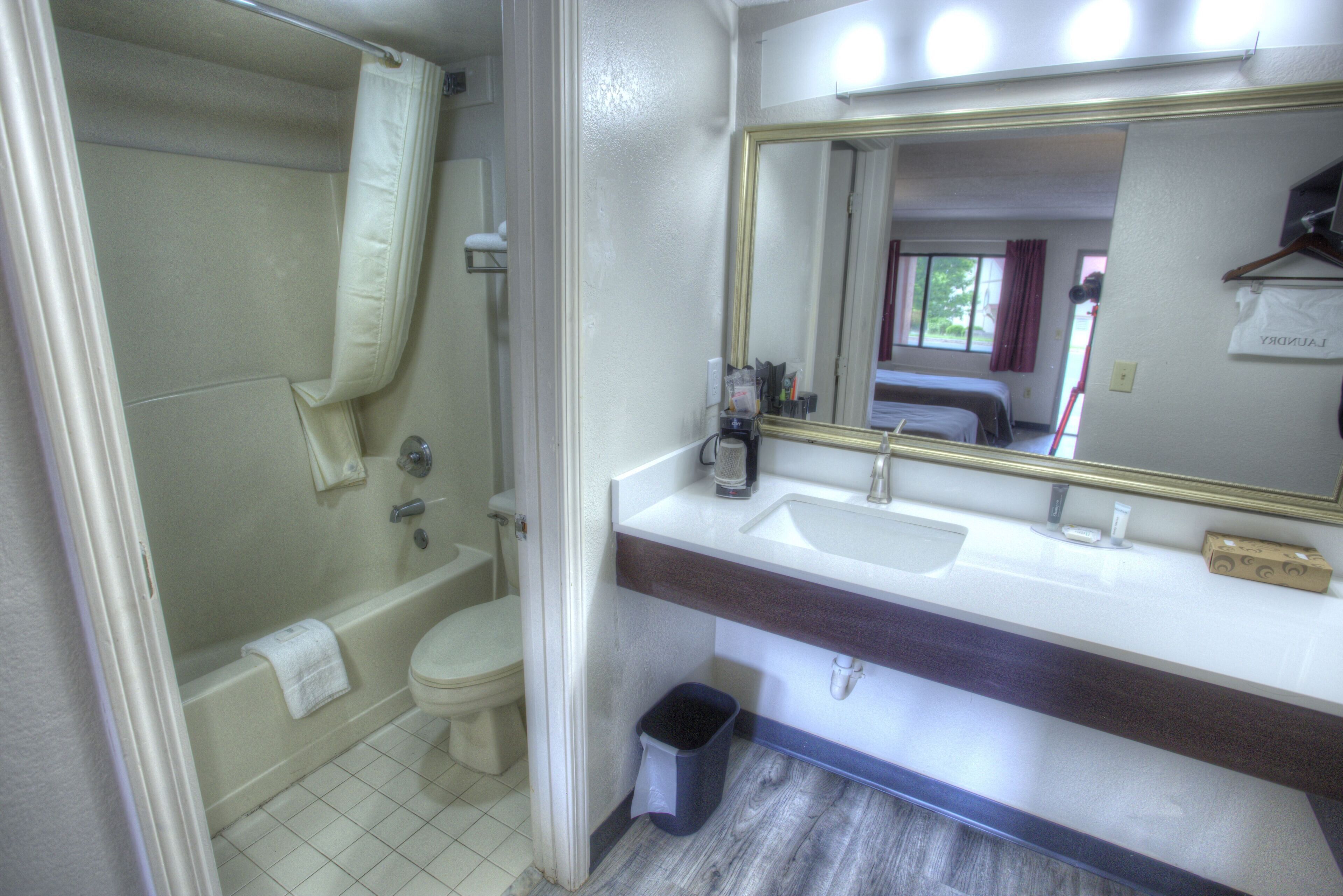 A bathroom with a bathtub, toilet, and sink.